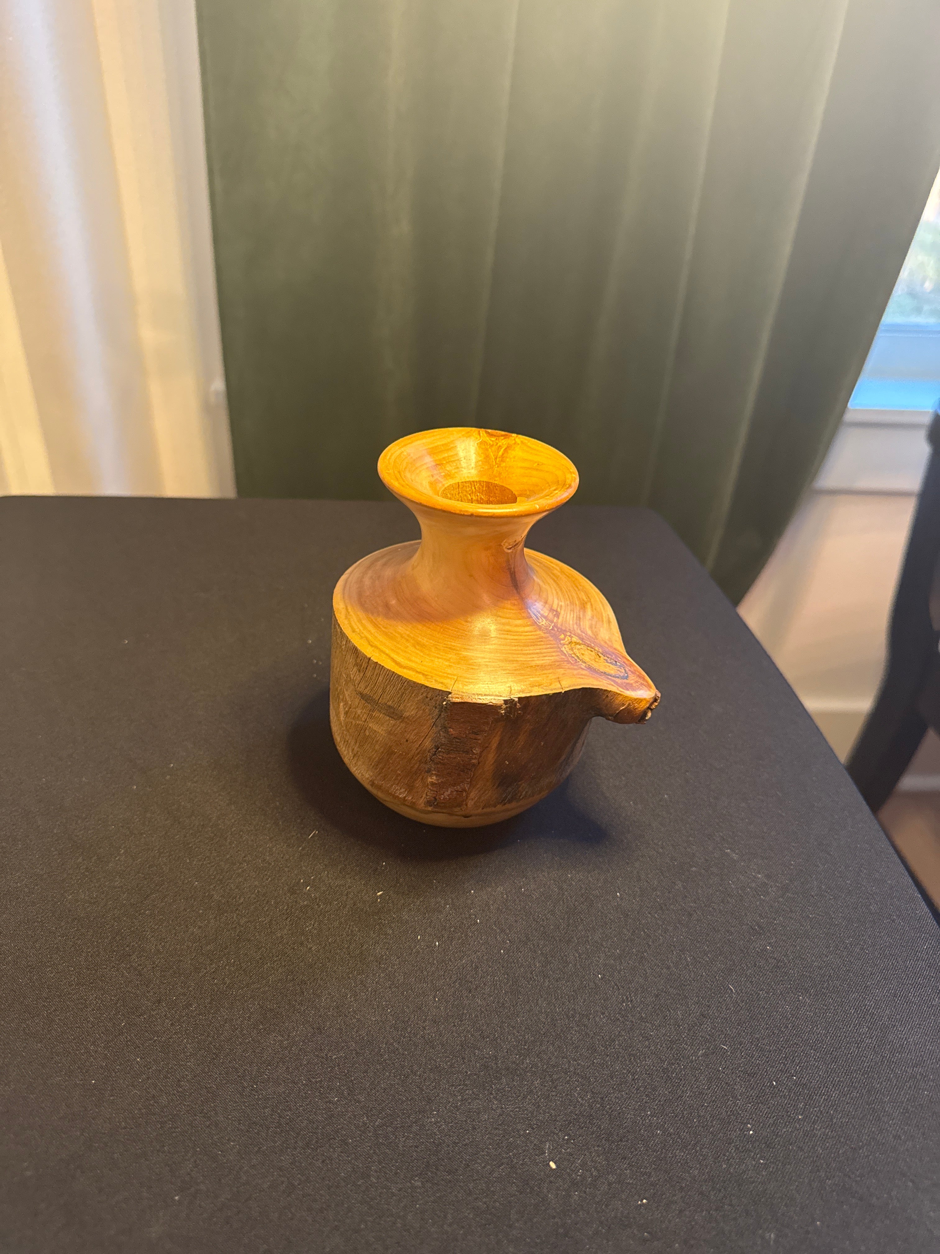 Hand-turned wooden decorative piece with carved figure by Spinning Aspen Studios.