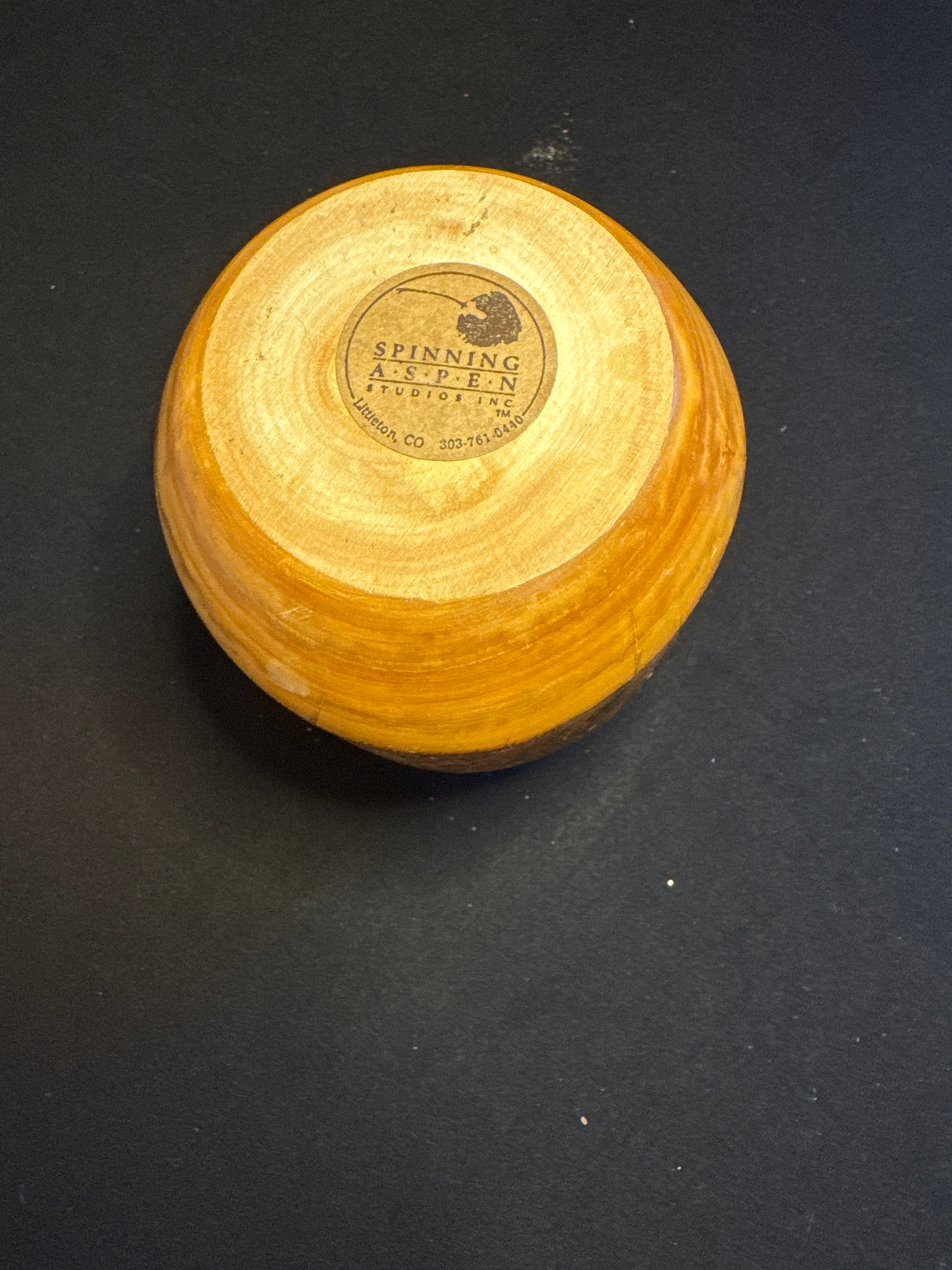 Hand-turned wooden decorative piece with carved figure by Spinning Aspen Studios.