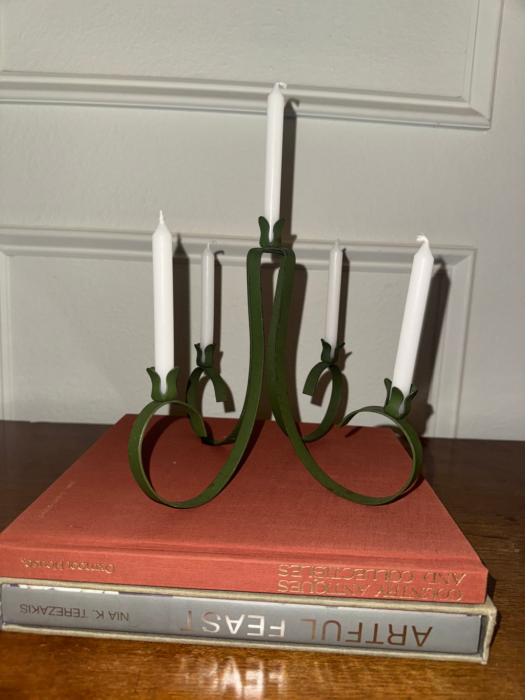 A dark green, five-arm metal candelabra with taper candles.