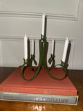 A dark green, five-arm metal candelabra with taper candles.
