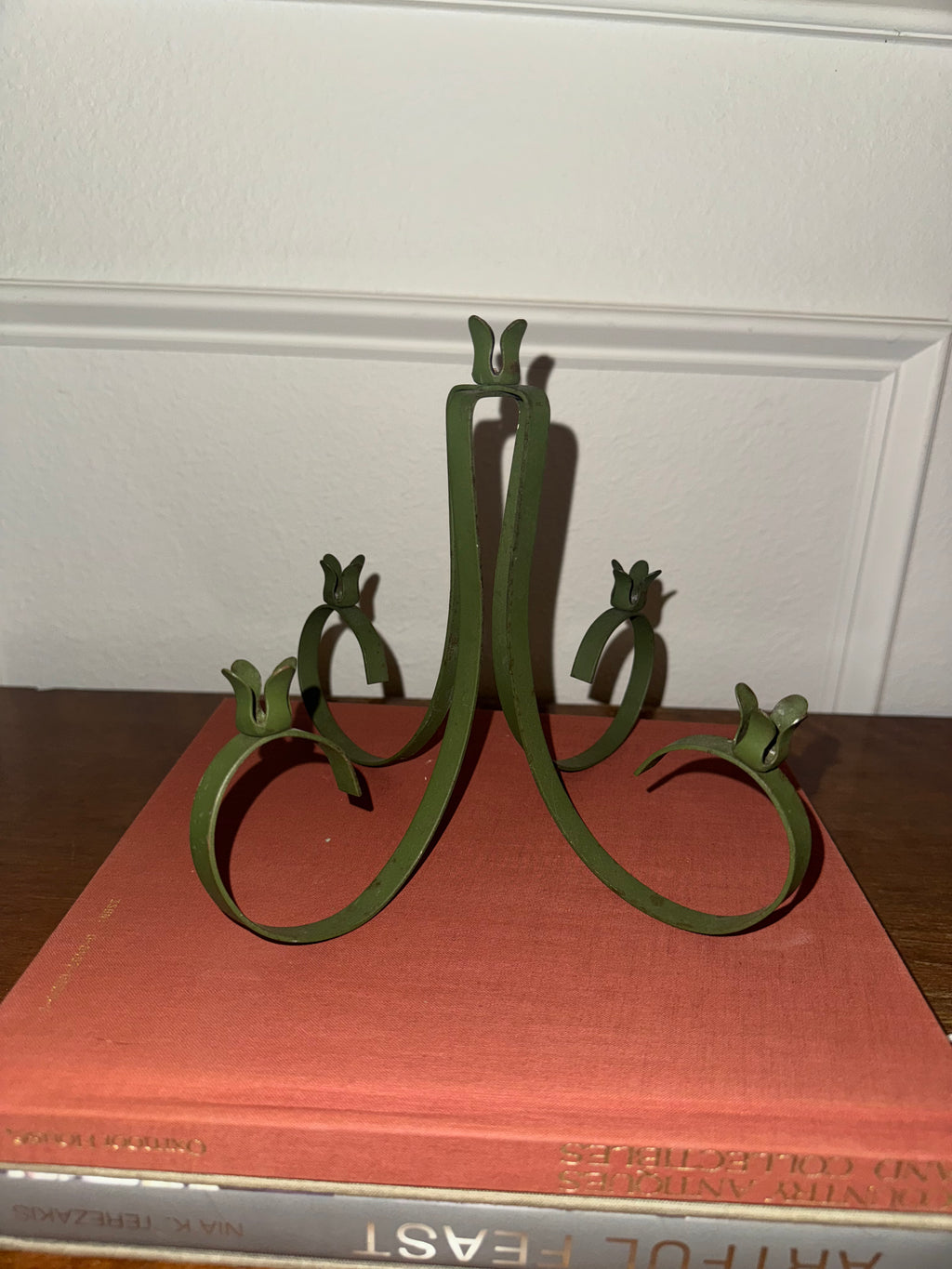 A dark green, five-arm metal candelabra with taper candles.