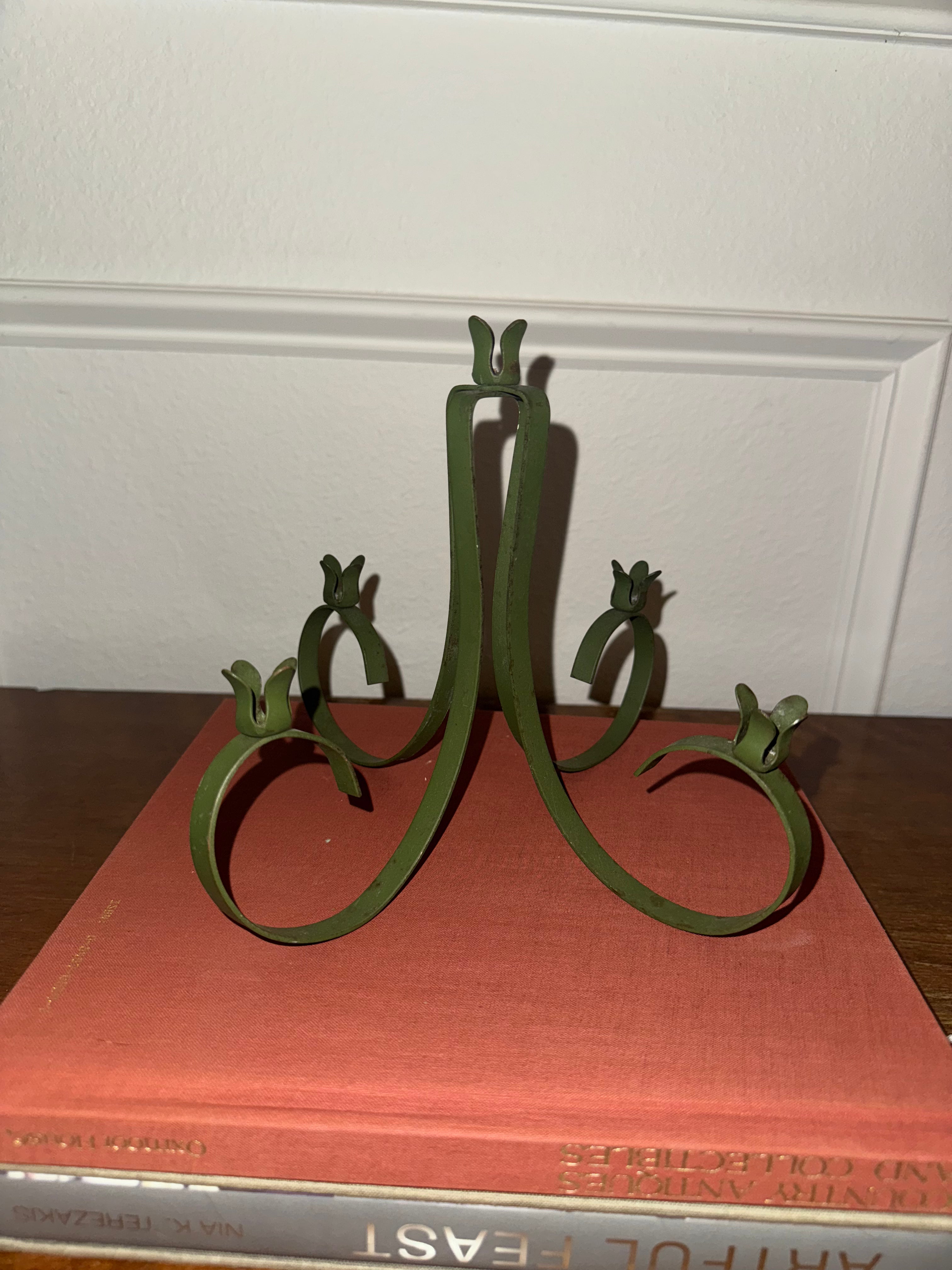 A dark green, five-arm metal candelabra with taper candles.