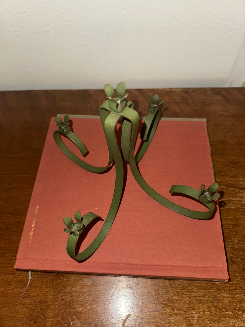 A dark green, five-arm metal candelabra with taper candles.